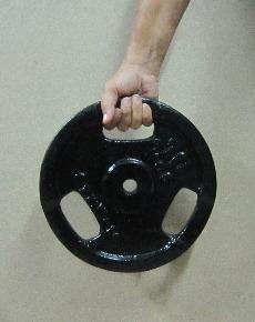 hand holding an olympic weight plate with handgrips